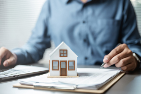 Wooden toy house on top of documents